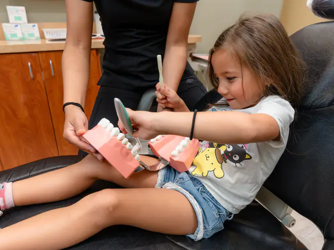 A parent and child speaking with a dental professional during a preventive dental visit.
