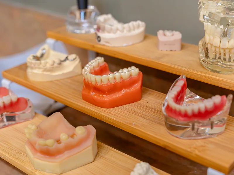 Upper and lower full dentures displayed on a clean neutral background.